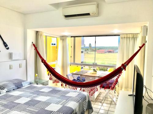 a bedroom with a bed and a hammock in a room at Gavoa Resort - 2 quartos - BL D apt 209 in Igarassu