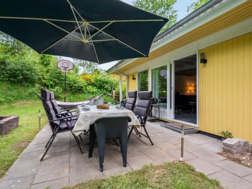 a patio with a table and chairs and an umbrella at Holiday Home Ethil - 300m to the inlet in The Liim Fiord by Interhome in Lihme