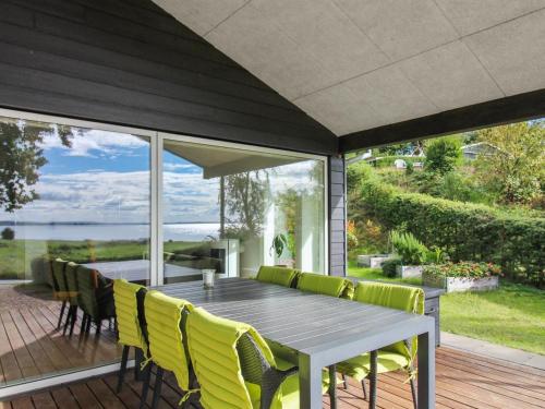 un comedor al aire libre con mesa y sillas amarillas en Holiday Home Elissa - 50m to the inlet in The Liim Fiord by Interhome, en Roslev