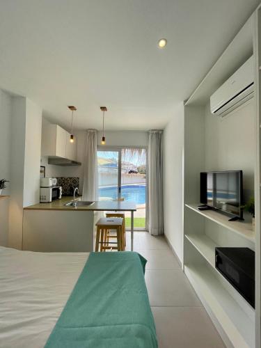 a bedroom with a bed and a kitchen with a table at Apartaments La Perla Negra in Cala Ratjada