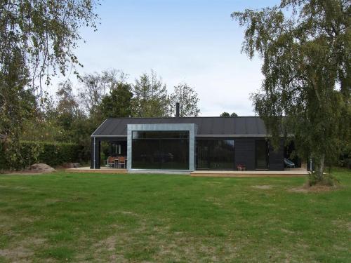 a black and white house with a large yard at Holiday Home Yukon - 150m from the sea in SE Jutland by Interhome in Odder