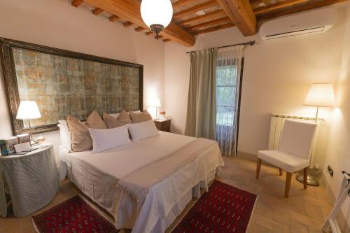 a bedroom with a bed and a table and a chair at Agriturismo Borgo di Campagna Il Tesoro in Torre Alfina