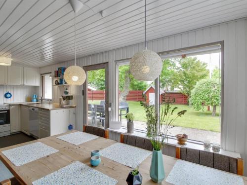 een keuken met een houten tafel en een groot raam bij Holiday Home Cristina - from the sea in SE Jutland by Interhome in Odder