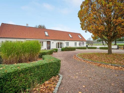 ein weißes Haus mit einem Baum und einer Auffahrt in der Unterkunft Holiday Home Malinda - 500m from the sea in SE Jutland by Interhome in Odder