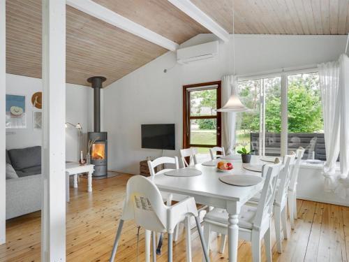 a white dining room with a white table and chairs at Holiday Home Morten - 500m from the sea in Djursland and Mols by Interhome in Ebeltoft