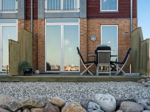 um pátio com cadeiras e uma mesa em frente a um edifício em Apartment Line - 10m from the sea in Djursland and Mols by Interhome em Glesborg