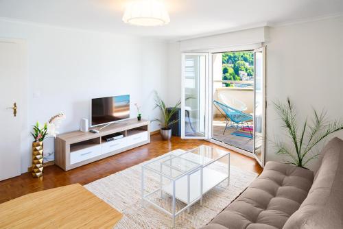 uma sala de estar com um sofá e uma televisão em Lake View - Appt Central 2 Bedroom, 1 Bath em Montreux