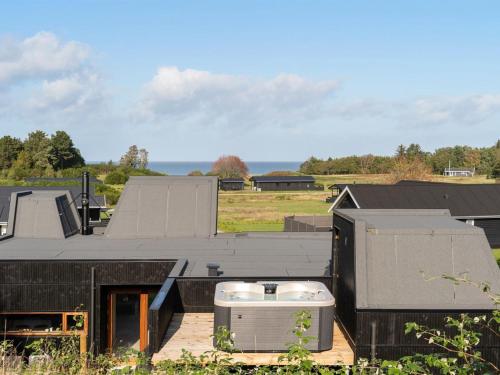 una casa negra con bañera de hidromasaje en la azotea en Holiday Home Fritze - 400m from the sea in Djursland and Mols by Interhome, en Glesborg