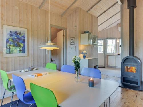 uma sala de jantar com uma mesa e cadeiras e um fogão em Holiday Home Raafael - 175m from the sea in Djursland and Mols by Interhome em Knebel