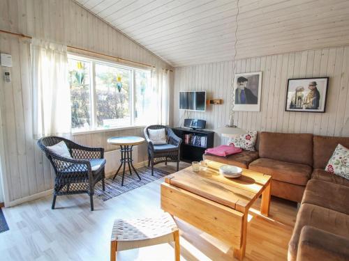 un soggiorno con divano, sedie e tavolo di Holiday Home Axilen - 1km from the sea in Djursland and Mols by Interhome a Grenå
