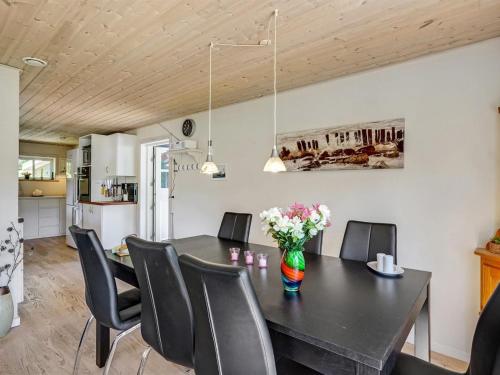 ein Esszimmer mit einem schwarzen Tisch und Stühlen in der Unterkunft Holiday Home Edele - 800m from the sea in Djursland and Mols by Interhome in Glesborg