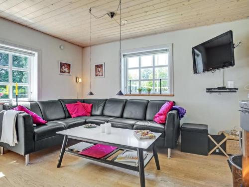 ein Wohnzimmer mit einem Sofa und einem Tisch in der Unterkunft Holiday Home Edele - 800m from the sea in Djursland and Mols by Interhome in Glesborg