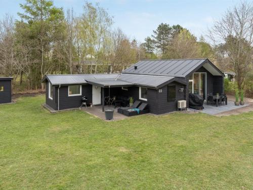 una casa negra con patio en Holiday Home Sunja - 450m from the sea in Djursland and Mols by Interhome, en Brøndstrup