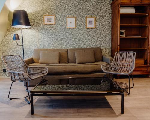 a living room with a couch and two chairs at Hotel Le Grimaldi by Happyculture in Nice