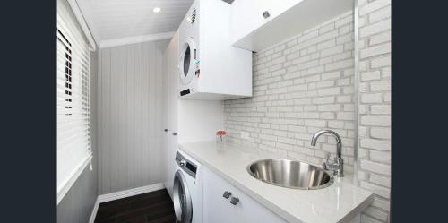 a kitchen with a sink and a brick wall at MJ's 2 bedroom luxury style apartment in Ipswich