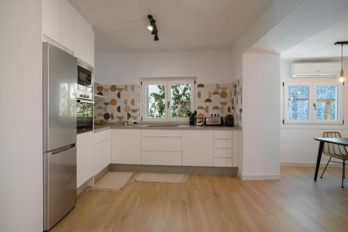 a kitchen with white cabinets and a table at Apartamento Essence by Solset in Frigiliana