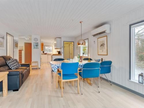 - une salle à manger et un salon avec une table et des chaises dans l'établissement Holiday Home Teofilka - 200m from the sea in NE Jutland by Interhome, à Sæby