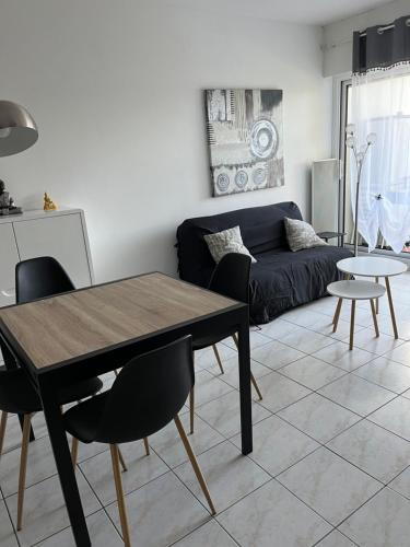 a living room with a table and a couch at Logement plein centre royan in Royan