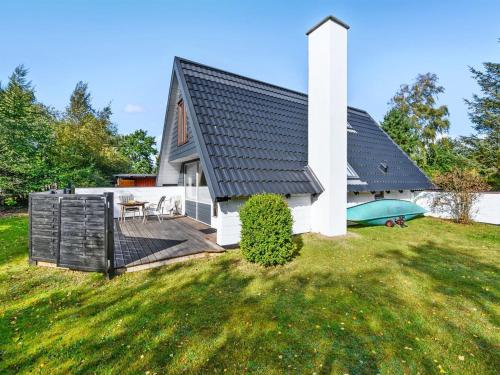 ein weißes Haus mit einer Terrasse und einem Hof in der Unterkunft Holiday Home Indira - 500m from the sea in Djursland and Mols by Interhome in Ørsted