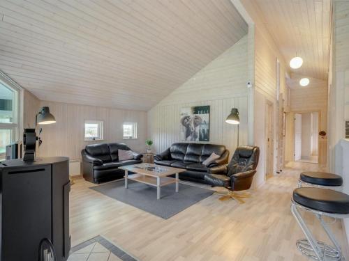 a living room with leather couches and a table at Holiday Home Femke - 250m to the inlet in NE Jutland by Interhome in Storvorde