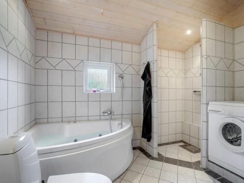 a bathroom with a tub and a toilet and a sink at Holiday Home Femke - 250m to the inlet in NE Jutland by Interhome in Storvorde