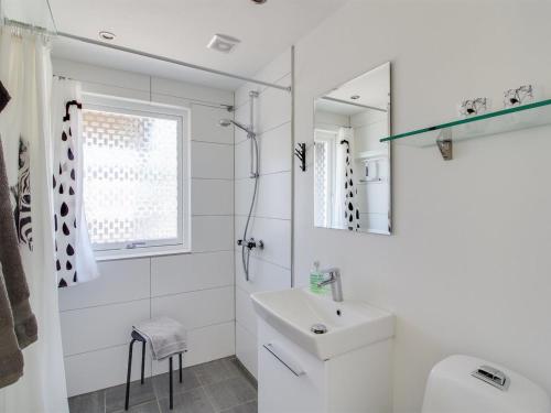 a white bathroom with a sink and a mirror at Holiday Home Teodora - 450m from the sea by Interhome in Brøndstrup