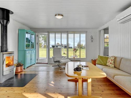 ein Wohnzimmer mit einem Sofa und einem Tisch in der Unterkunft Holiday Home Joon - 300m from the sea in Djursland and Mols by Interhome in Ørsted