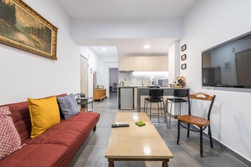 ein Wohnzimmer mit einem Sofa und einem Tisch in der Unterkunft Koukaki Home in Athen