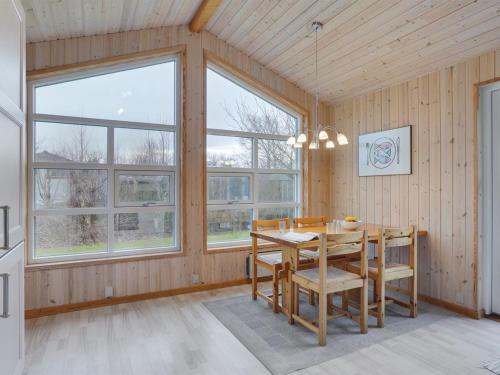 een eetkamer met een tafel en een aantal ramen bij Holiday Home Nelda - 300m to the inlet in NE Jutland by Interhome in Storvorde