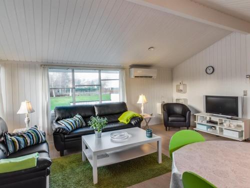uma sala de estar com um sofá e uma mesa em Holiday Home Cosima - 130m to the inlet in NE Jutland by Interhome em Storvorde