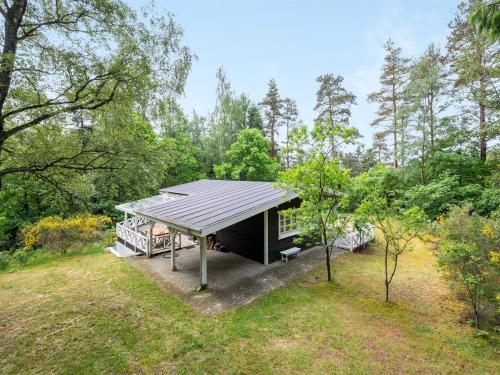 ein Haus im Wald mit einem Metalldach in der Unterkunft Holiday Home Belenda in SE Jutland by Interhome in Silkeborg