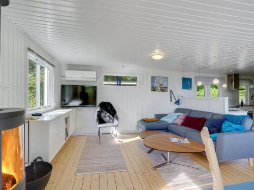 a living room with a blue couch and a table at Holiday Home Self - 400m to the inlet in The Liim Fiord by Interhome in Løgstrup