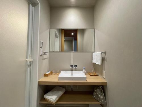 a bathroom with a white sink and a mirror at Kansai Airport Pine Villa in Kansai International Airport