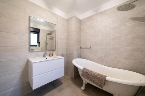 y baño con bañera blanca y lavamanos. en Exclusive Villa City, Beach & Golf, en Alicante