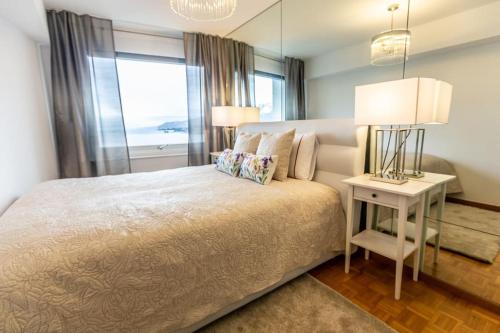 Perfect apartment Montreux centre - Lake View في مونترو: غرفة نوم بسرير كبير ونافذة