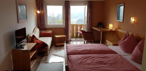 um quarto com uma cama, um sofá e uma janela em Gästehaus Eckstein em Oy-Mittelberg
