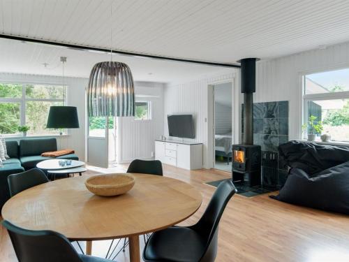 een woonkamer met een tafel en een open haard bij Holiday Home Hilde - 1-7km from the sea in NE Jutland by Interhome in Sæby