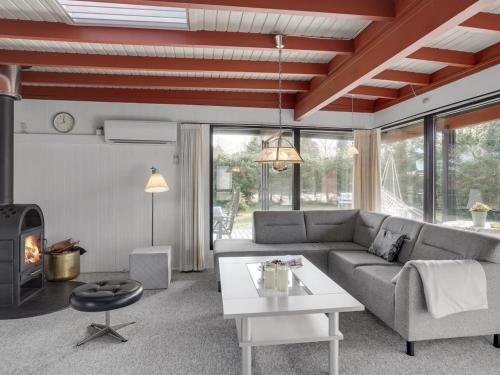 uma sala de estar com um sofá, uma mesa e uma lareira em Holiday Home Polina - 800m from the sea in NE Jutland by Interhome em Hals