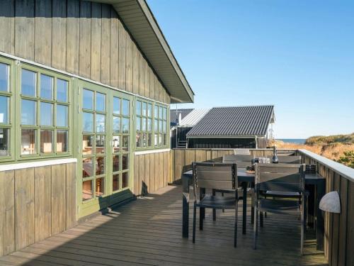 um deque com uma mesa e cadeiras num edifício em Holiday Home Annabell - 150m from the sea in NE Jutland by Interhome em Sæby