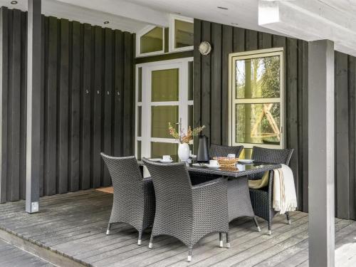 un patio con mesa y sillas en una terraza en Holiday Home Ajten - 150m from the sea in NE Jutland by Interhome, en Saeby