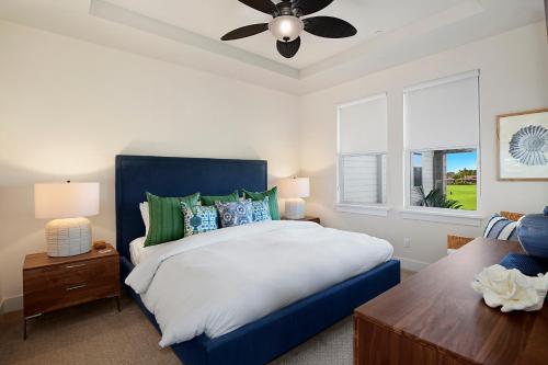 a bedroom with a blue bed and a ceiling fan at Pili Mai 6K in Koloa