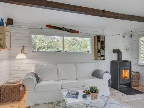 uma sala de estar com um sofá branco e uma lareira em Holiday Home Susannah - from the sea in NE Jutland by Interhome em Hals