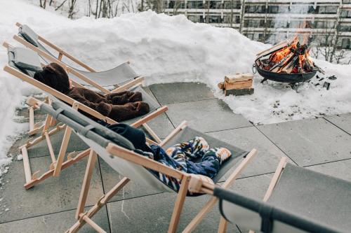 a person laying in a chair next to a fire at Charming chalet with sauna + views! in Bad Gastein