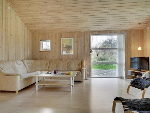 ein Wohnzimmer mit einem Sofa und einem Tisch in der Unterkunft Holiday Home Thorketil - 1-1km from the sea in NE Jutland by Interhome in Hals