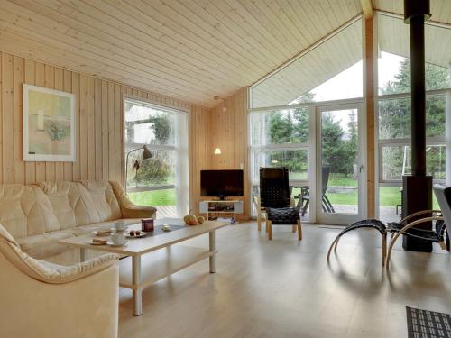 ein Wohnzimmer mit einem Sofa und einem Tisch in der Unterkunft Holiday Home Thorketil - 1-1km from the sea in NE Jutland by Interhome in Hals
