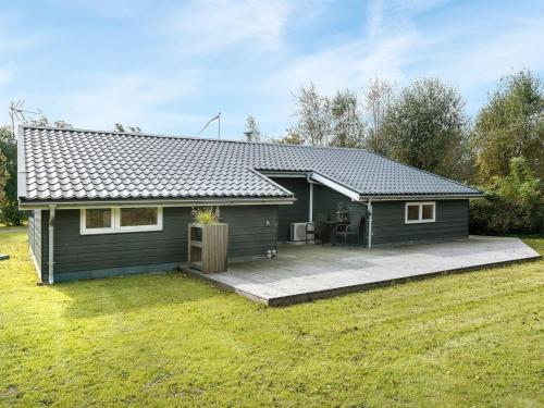 uma pequena casa com um pátio num quintal em Holiday Home Erhardt - 800m from the sea in NE Jutland by Interhome em Hals