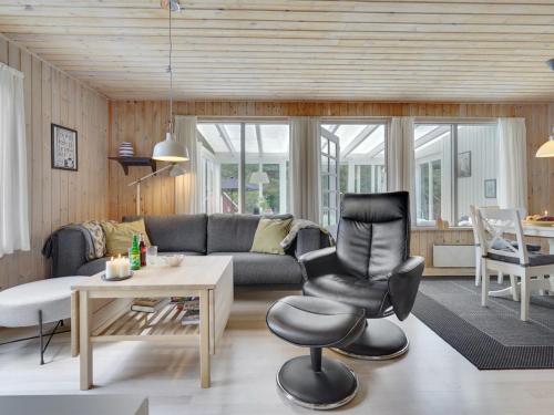 sala de estar con sofá y silla en Holiday Home Ane - 1-7km from the sea in NE Jutland by Interhome, en Hals