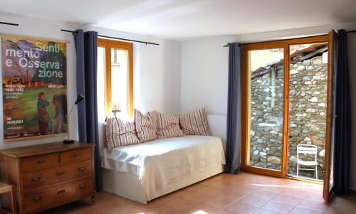 1 dormitorio con 1 cama, vestidor y ventana en Casa al Sasso, en Bedigliora