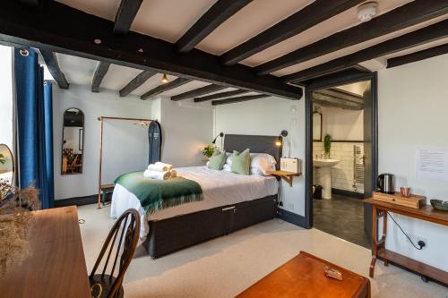 Un dormitorio con una cama grande y una mesa. en Royal Oak Pub, en Cartmel