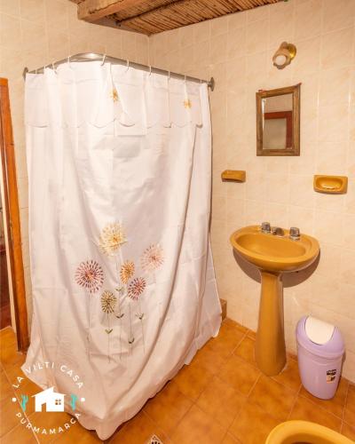 ein Bad mit einem Duschvorhang mit Blumen darauf in der Unterkunft La Vilti casa de Purmamarca in Purmamarca